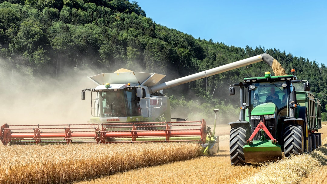 combine-harvester-working-in-a-wheat-field-with-a-tractor-9q-yfktxq88